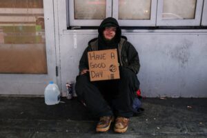 Nathan, 22, originally from Texas, who said he has been homeless since he was 16, sits with a sign along 42nd Street in New York City March 1, 2023. Each year, an estimated 4.2 million youth and young adults experience homelessness. (OSV News photo/Shannon Stapleton, Reuters)