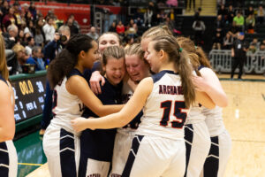 The Lumen Christi Catholic High School girls’ basketball team scream in excitement after winning their way to a state championship title. (Courtesy of Tyler Sutton Photography)
